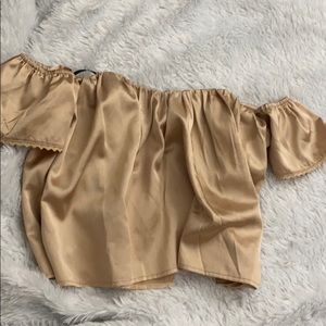 Off the shoulder gold crop top .